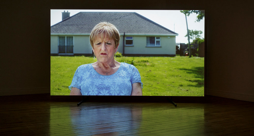 Installation image of Christine outside her home in rural Galway; a home she self-built for her family. RHA, Dublin, 2018. Photographer Paul McCarthy