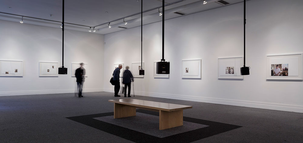 Image shows people viewing the exhibition of framed selfies and audio installation at the RHA Gallery, Dublin. 2018.